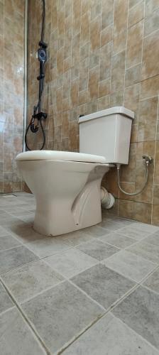 a toilet in a bathroom with a camera on the wall at 1 minute walk to Victoria Mall in Entebbe