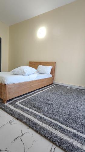 a bedroom with a bed and a rug on the floor at 1 minute walk to Victoria Mall in Entebbe