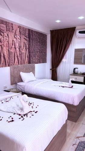 a hotel room with two beds with flowers on them at Locanda pyramids view in Cairo