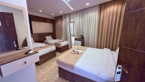 a hotel room with two beds and a television at Locanda pyramids view in Cairo