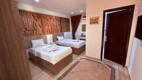 a hotel room with two beds and a doorway at Locanda pyramids view in Cairo