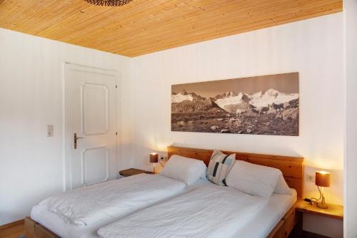 a bed in a bedroom with a painting on the wall at Apart Mia in Grossried
