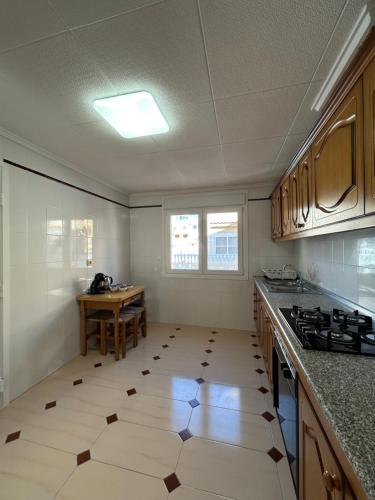 an empty kitchen with a table in the distance at Casa familiar in Torrevieja