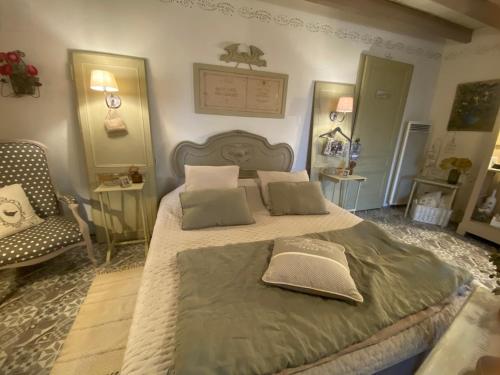 a bedroom with a large bed and a chair at Ma demeure dans les vignes in Sainte-Foy-la-Longue