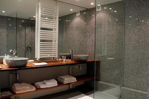 a bathroom with two sinks and a shower at La Maison du Vignoble piscine, tennis, Wallbox in Lectoure