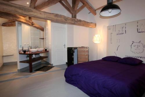 a bedroom with a purple bed and a sink at La Maison du Vignoble piscine, tennis, Wallbox in Lectoure