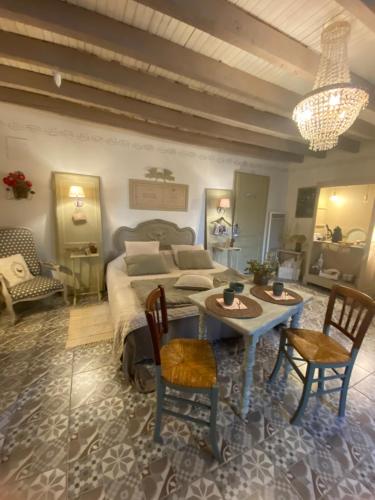 a bedroom with a bed and a table and chairs at Ma demeure dans les vignes in Sainte-Foy-la-Longue