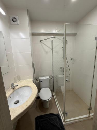 a bathroom with a shower and a toilet and a sink at Hotel Cosmos in Ruse
