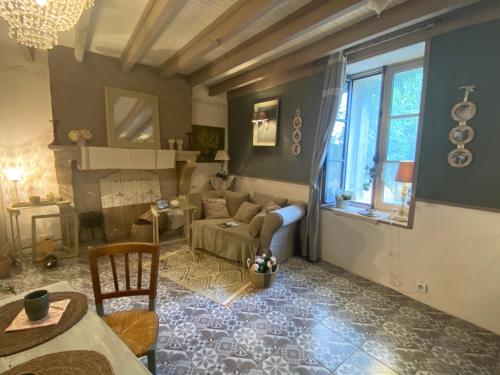 a living room with a couch and a table at Ma demeure dans les vignes in Sainte-Foy-la-Longue