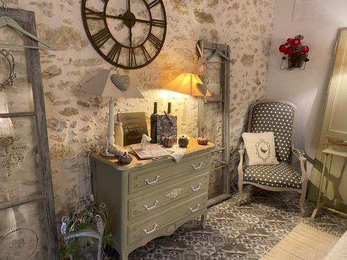a room with a dresser and a clock on the wall at Ma demeure dans les vignes in Sainte-Foy-la-Longue