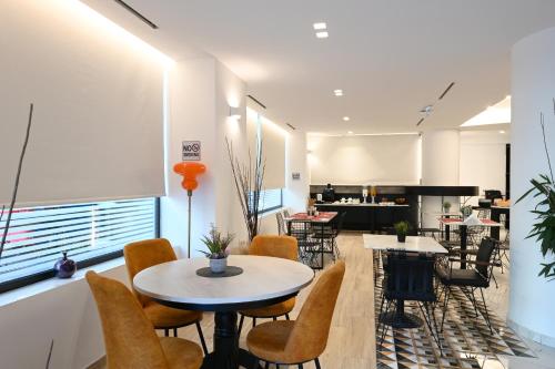 a restaurant with tables and chairs and a kitchen at Urban Core Residence in Athens