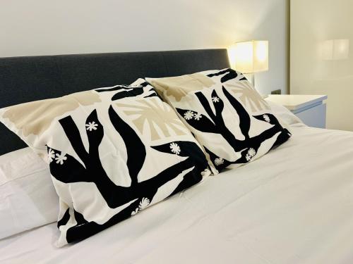 a bed with a black and white blanket on it at Berkeley House in Eastbourne