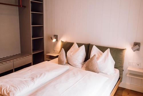 a bed with white sheets and pillows in a room at Schmidtburger Hof in Weiler
