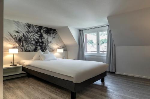 a bedroom with a large bed and a window at Hotel Vitznauerhof - Lifestyle Hideaway at Lake Lucerne in Vitznau