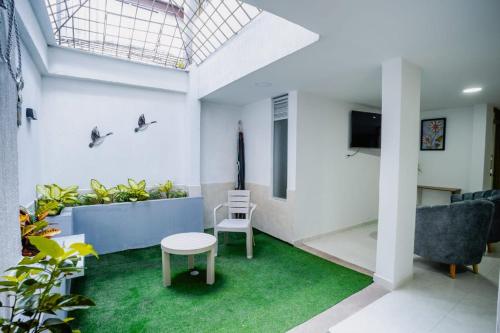 a living room with a couch and a tv and green carpet at Casa Fonla in Estación El Salto