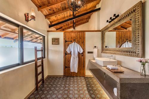 a bathroom with a sink and a mirror at SaffronStays Satori Hornbill, Ultra Luxe two bedroom Villa on 8 Acres Estate, By The Mulshi Lake in Mulshi