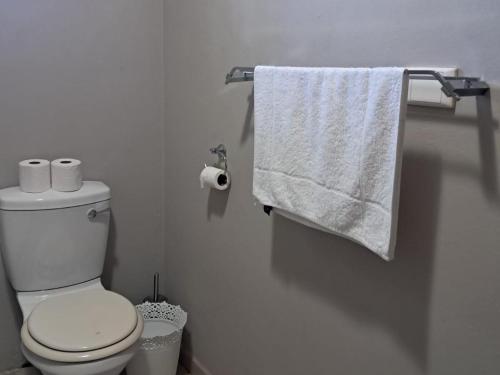 a white bathroom with a toilet and a towel at SeaXplore Lodge & Dive Center in Sodwana Bay