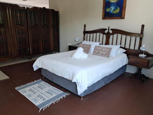 a bedroom with a large bed with a wooden headboard at SeaXplore Lodge & Dive Center in Sodwana Bay