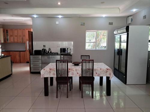 a kitchen with a table with chairs and a refrigerator at SeaXplore Lodge & Dive Center in Sodwana Bay