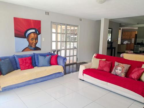 a living room with two couches and a painting on the wall at SeaXplore Lodge & Dive Center in Sodwana Bay
