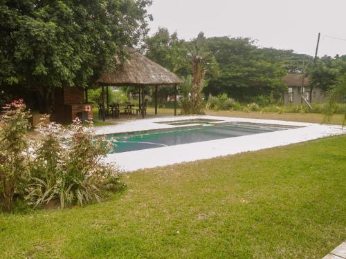 a swimming pool in a yard with a gazebo at SeaXplore Lodge & Dive Center in Sodwana Bay
