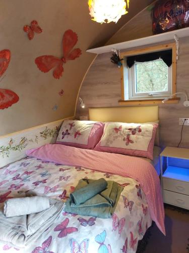 a bedroom with a bed with butterflies on the wall at Butterfly PODika in Lerwick