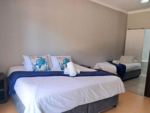 a bedroom with two beds with blue and white pillows at SeaXplore Lodge & Dive Center in Sodwana Bay