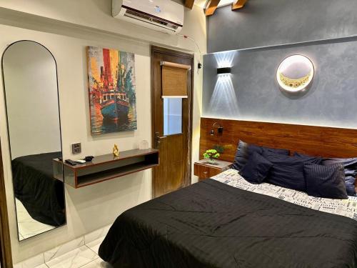 a bedroom with a large bed and a mirror at Beachfront Studios by Virani in Karachi