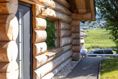 una finestra sul lato di una casa di tronchi di La Tzarma a Granges