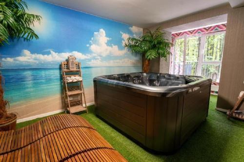 a bath tub in a room with a mural of the ocean at Kozubnik Apartment in Porąbka