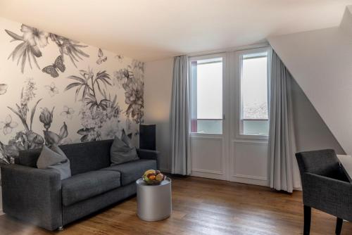 a living room with a couch and a window at Hotel Vitznauerhof - Lifestyle Hideaway at Lake Lucerne in Vitznau