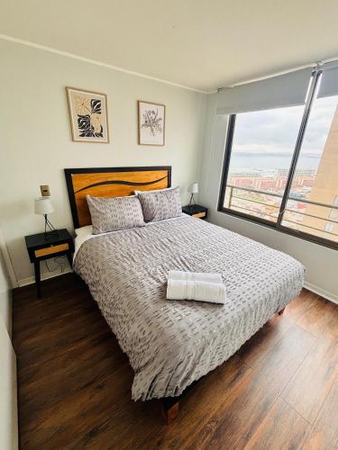 a bedroom with a large bed with a large window at Experiencia Terramar-1hab-1Bañó-1estac in Antofagasta
