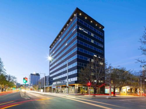 a tall building with lights on the side of a street at The Sebel Canberra Civic in Canberra