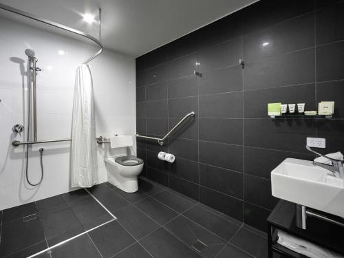 a black and white bathroom with a toilet and a sink at The Sebel Canberra Civic in Canberra