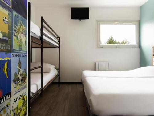 a room with two bunk beds and a window at Hôtel F1 Reims Tinqueux in Reims