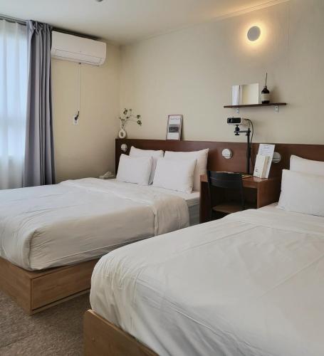 a hotel room with two beds and a desk at jeonju hotel book and type in Jeonju