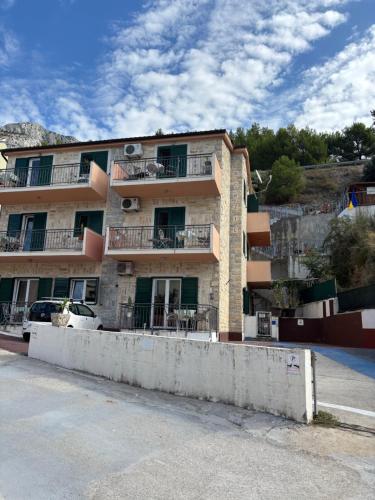 a building with balconies on the side of a street at Nemira IX Vacations in Omiš