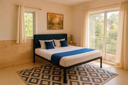 a bedroom with a bed with blue and white pillows at Tulsi Villa in Panchgani