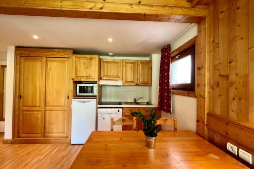 eine Küche mit Holzschränken und einem weißen Kühlschrank in der Unterkunft Second de Cordée in Combloux