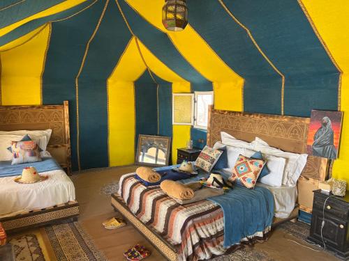 a room with two beds in a circus tent at Sahara Majestic Luxury Camp in Merzouga