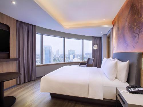 Ένα ή περισσότερα κρεβάτια σε δωμάτιο στο Mercure Jakarta Gatot Subroto