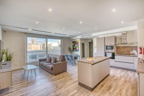 Una cocina y una sala de estar con un sofá y una mesa. en Stella Maris - 'Star of the Sea' Penthouse-Sliema, en Sliema