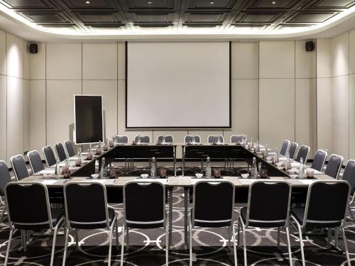 a conference room with a large table and chairs at Movenpick Surabaya City in Surabaya