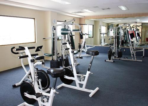 a gym with several tread machines in a room at Hotel San Marcos Grand in Culiacán