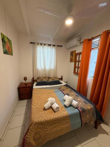 a bedroom with a bed with two towels on it at Kaz à Zozio - F2 au calme à Bouillante in Bouillante