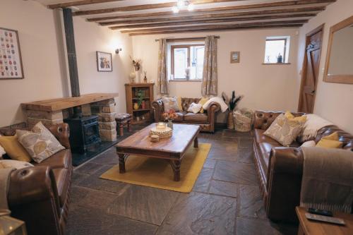 a living room with leather furniture and a fireplace at The Shippon Barn - A delightful haven for families in Wirral