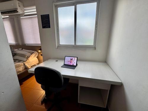 a laptop computer sitting on a desk next to a window at OUR HOME SAN ANTONIO in Cali