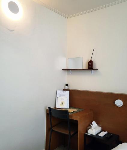 a desk in a hotel room with a chair at jeonju hotel book and type in Jeonju