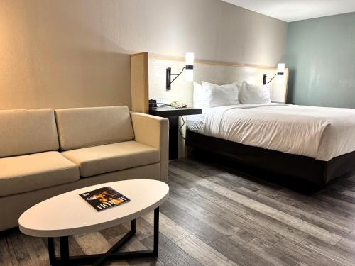 ein Hotelzimmer mit einem Bett, einer Couch und einem Tisch in der Unterkunft Wyndham Garden Lake Guntersville in Guntersville