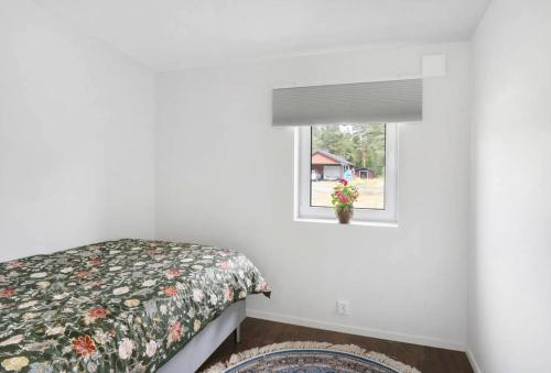 a bedroom with a bed and a window at Newly Built House with Free Parking in Scenic Nature in Umeå